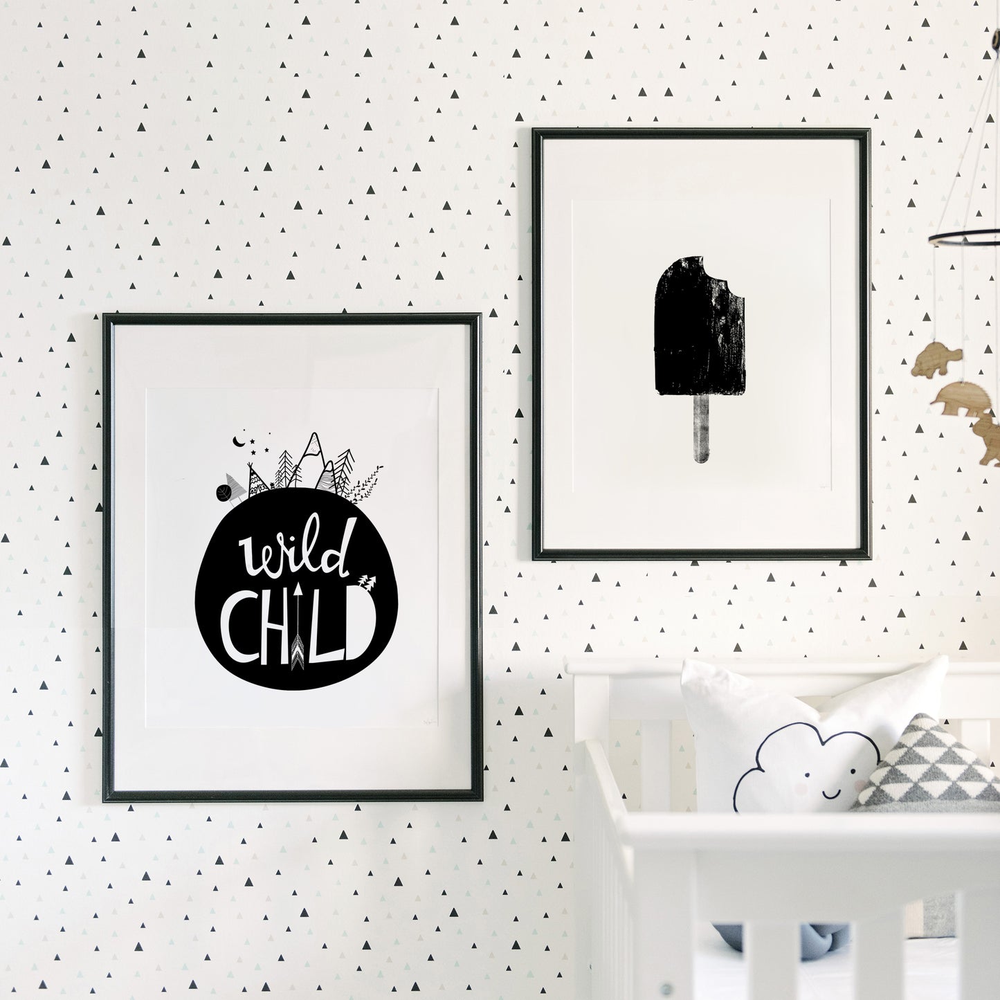 black and white nursery prints framed above crib